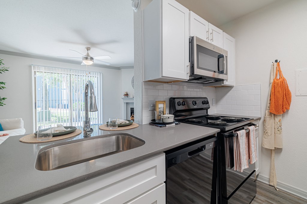 a kitchen with a sink and a stove and a microwave