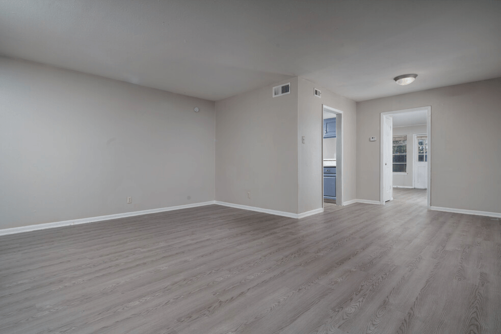 an empty living room with white walls and wood floors
