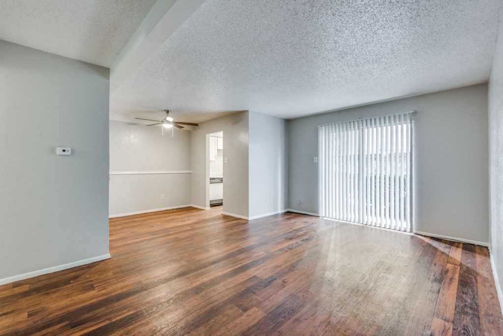 the spacious living room and dining room of an apartment