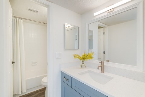 A white bathroom with a white sink and a white toilet.