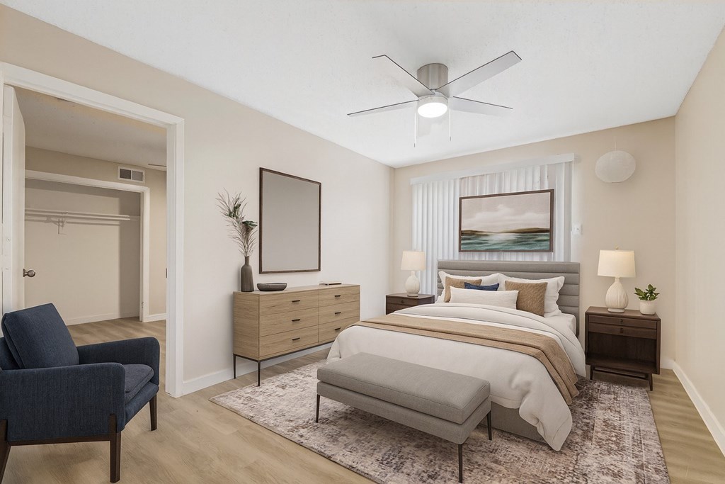 A bedroom with a bed, nightstand, and chair.