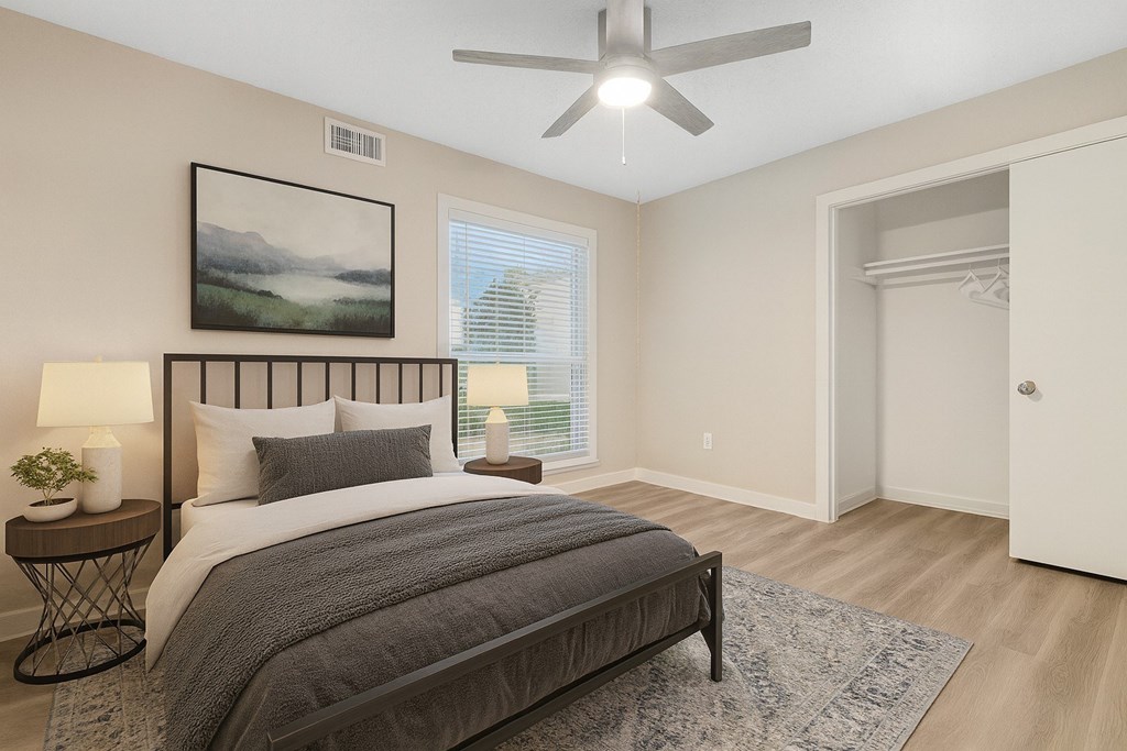 A bedroom with a large bed and a ceiling fan.