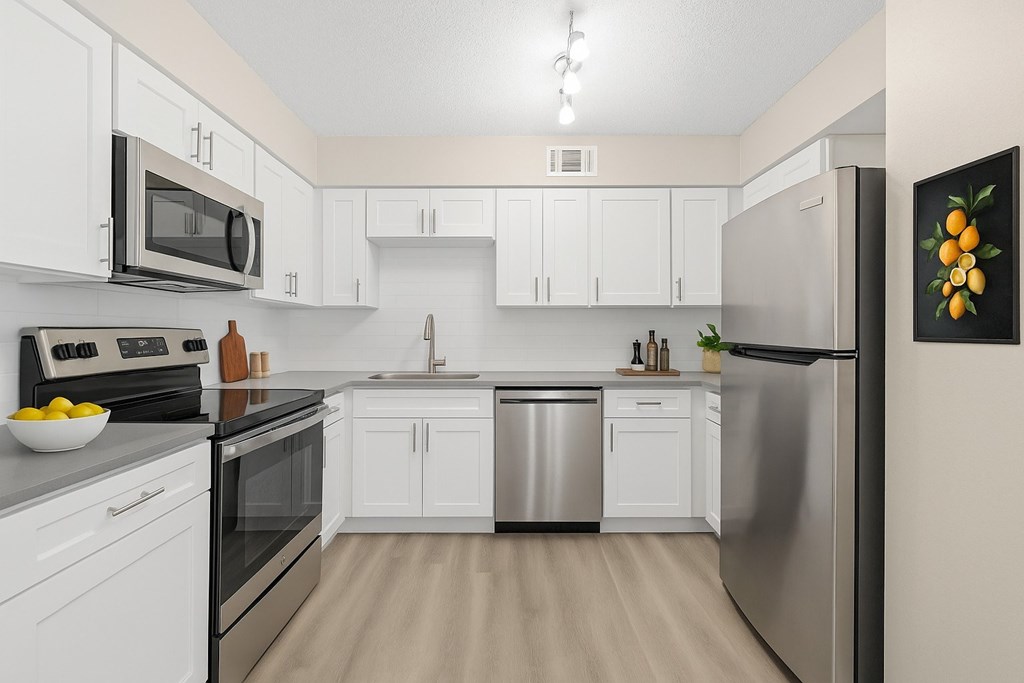 A kitchen with white cabinets and stainless steel appliances.