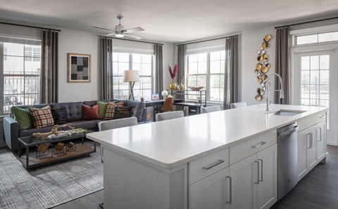 a kitchen and living room with a large white counter top