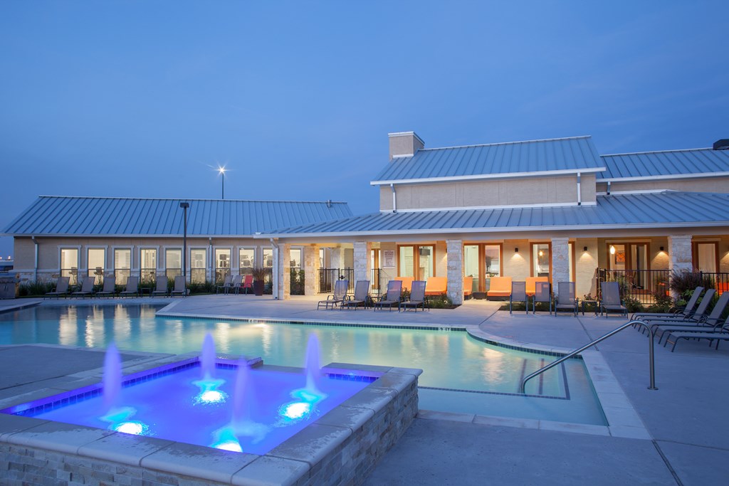 A pool with a fountain in the middle of it.
