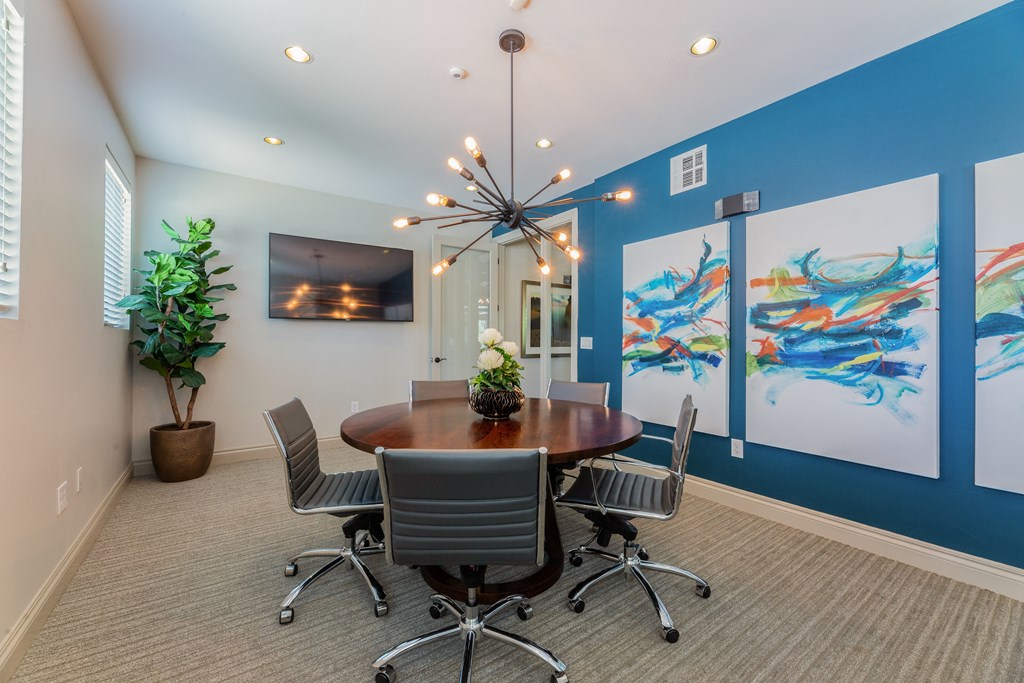 a conference room with a table and chairs and a chandelier