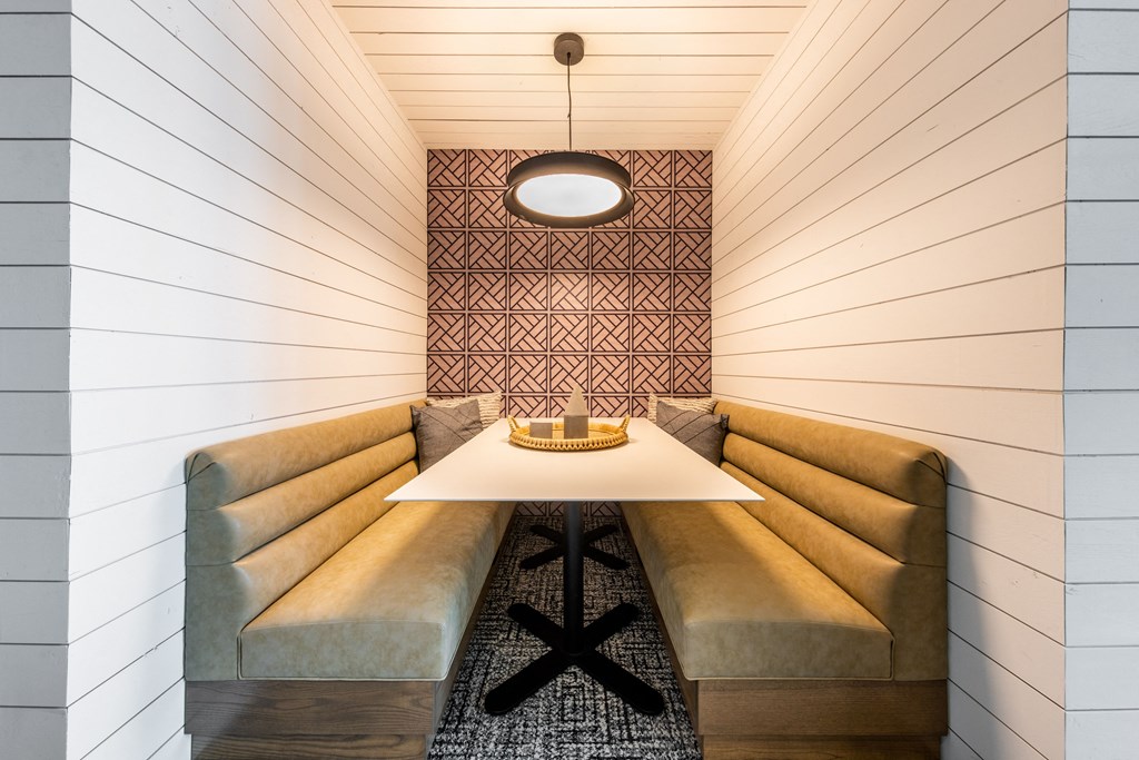 A long table with a yellow cushioned bench is in the middle of the room.