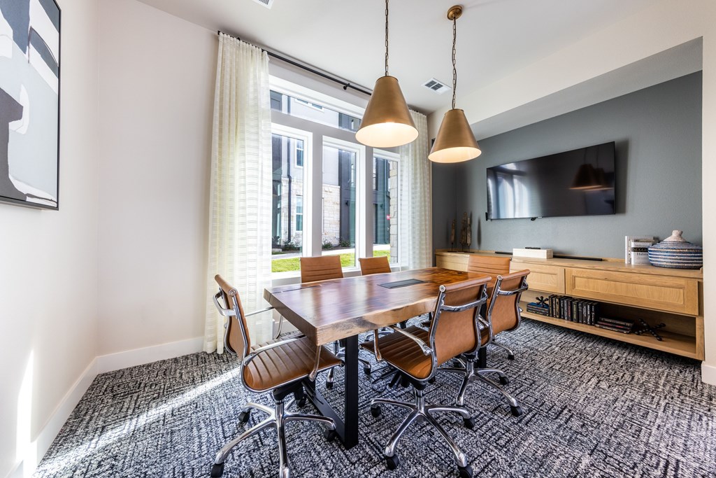 A conference room with a long table and chairs.