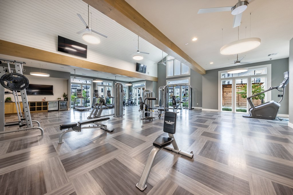 A gym with a variety of equipment including treadmills, weights, and exercise machines.