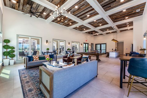 A spacious living room with a large grey sofa and a wooden coffee table.