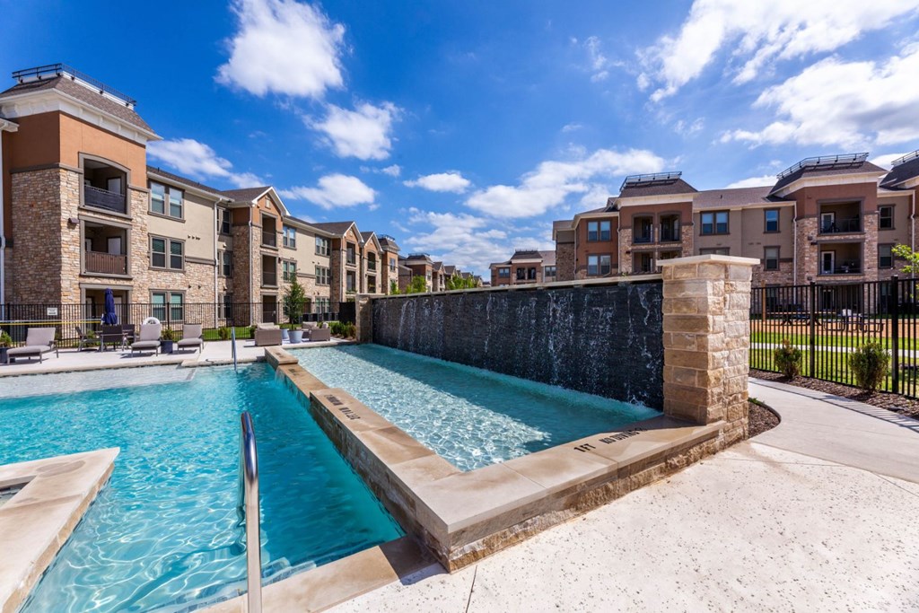 A swimming pool in front of apartment buildings.