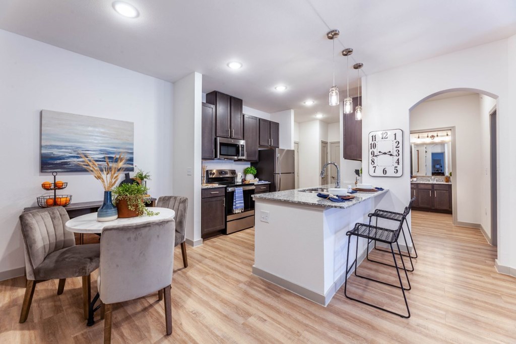 A modern kitchen with a dining table and chairs.