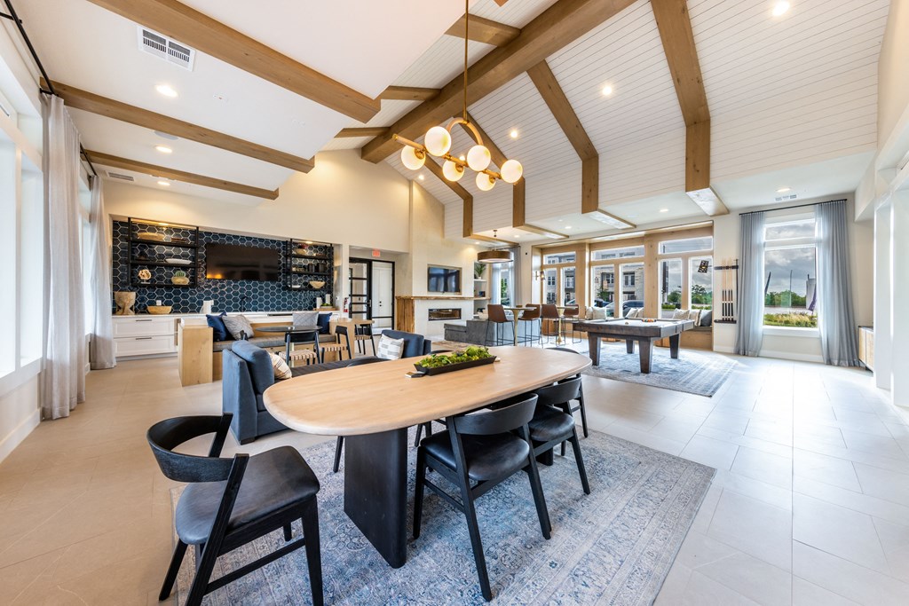 A modern dining room with a large table and chairs.