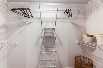 A white closet with shelves and hangers.