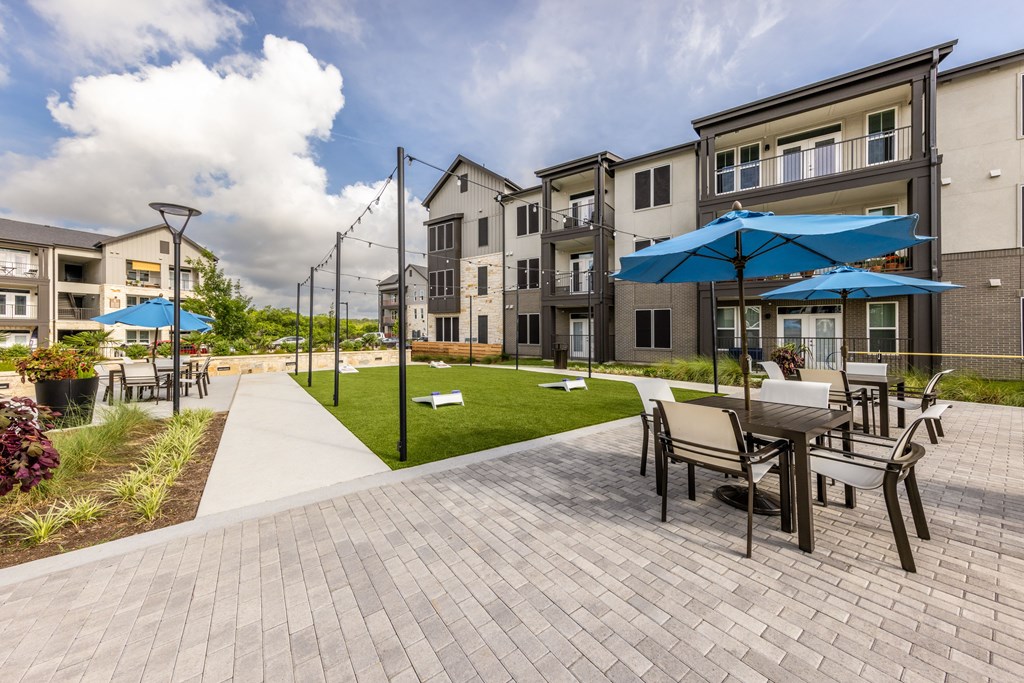 A sunny day at a residential complex with a walkway and seating area.