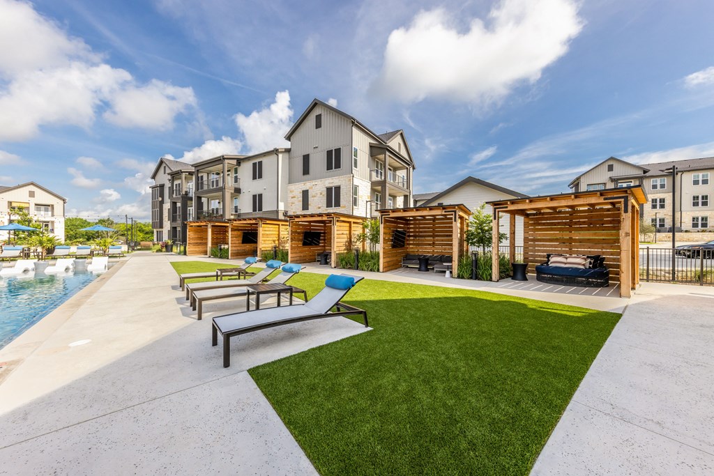 A sunny day at a resort with a pool and loungers.