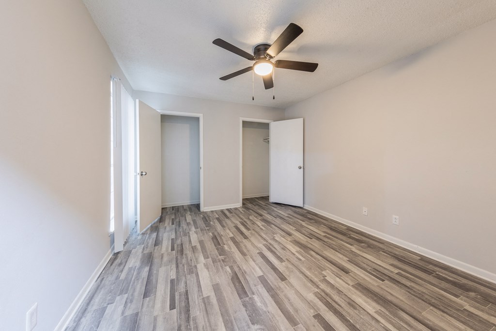 an empty living room with a ceiling fan