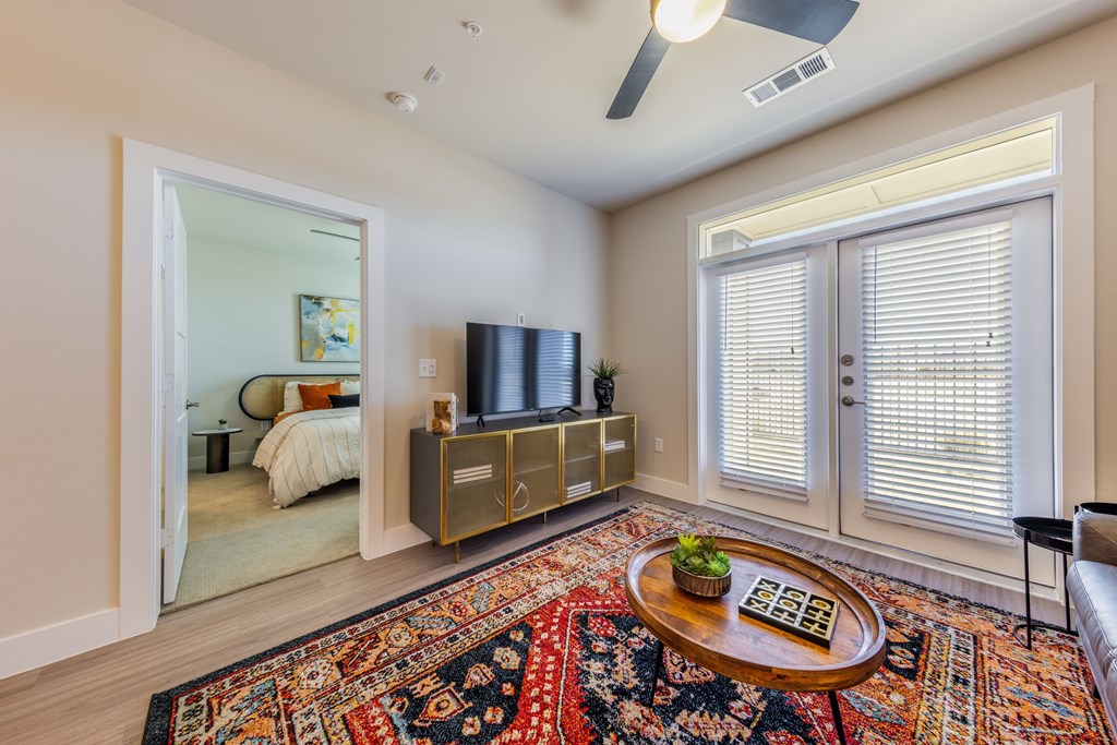 A living room with a rug, a coffee table, and a television.