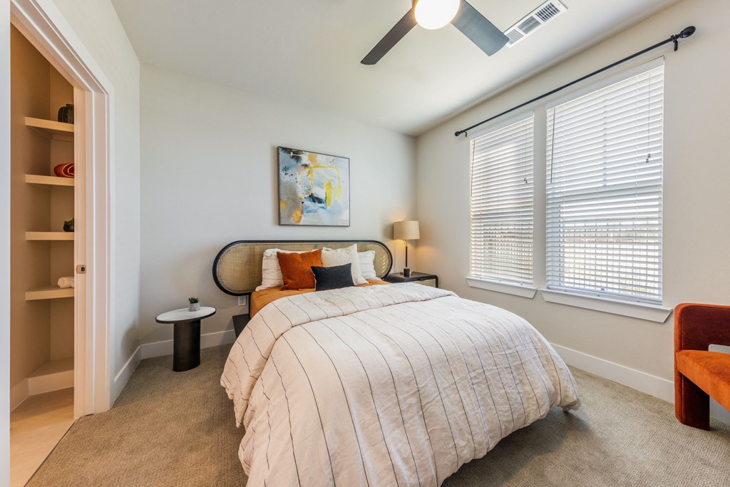 A bedroom with a bed, a chair, and a painting on the wall.
