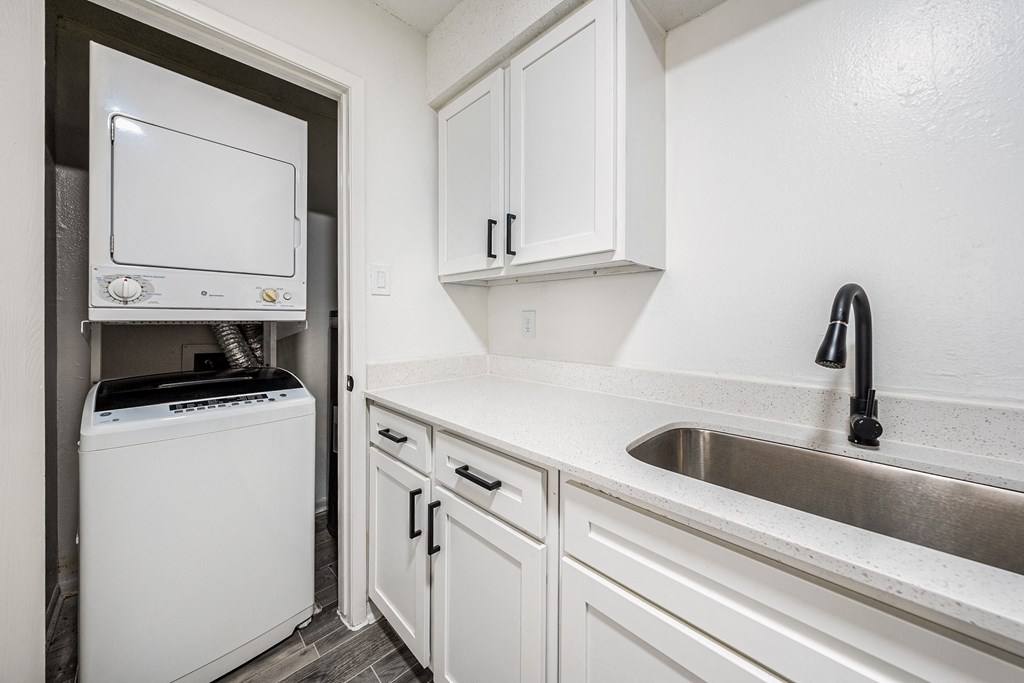 a kitchen with white cabinets and a sink and a refrigerator