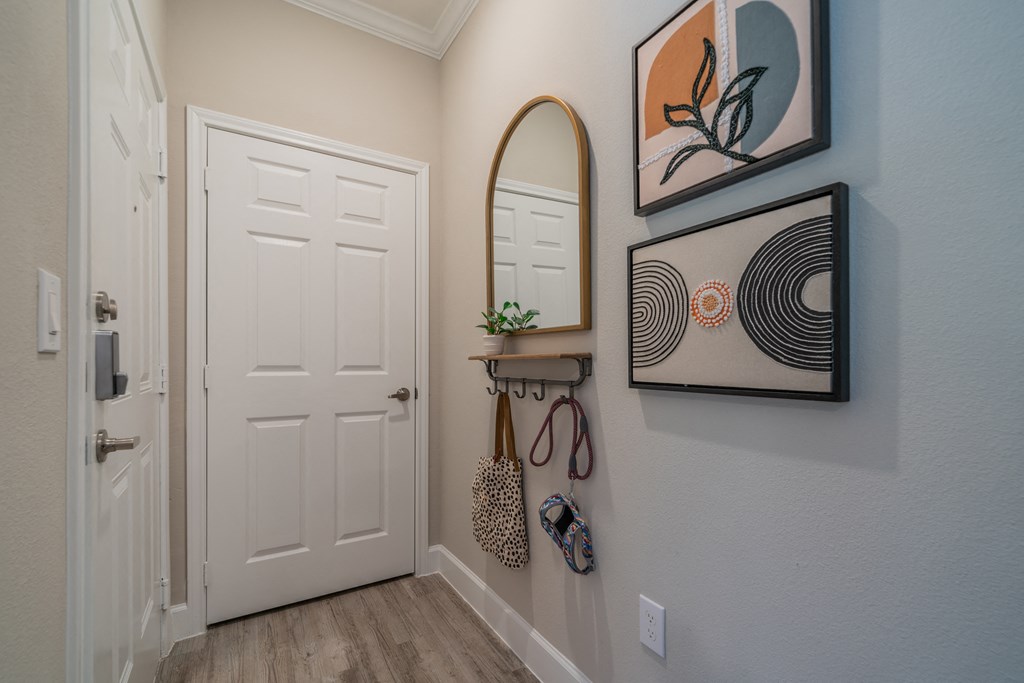 a hallway with a white door and a mirror on the wall