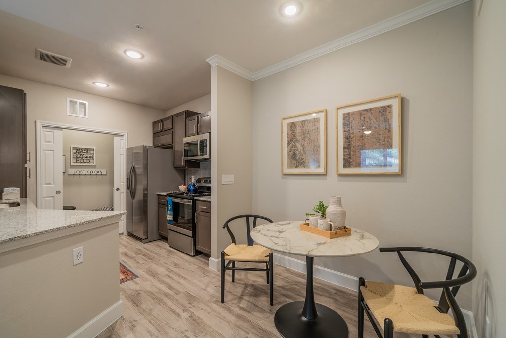 a kitchen and dining area with a small table and two chairs