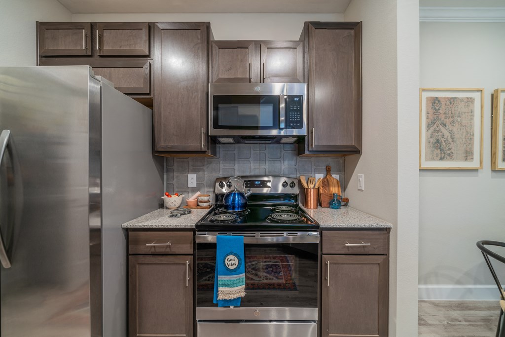 a kitchen with brown cabinets and stainless steel appliances