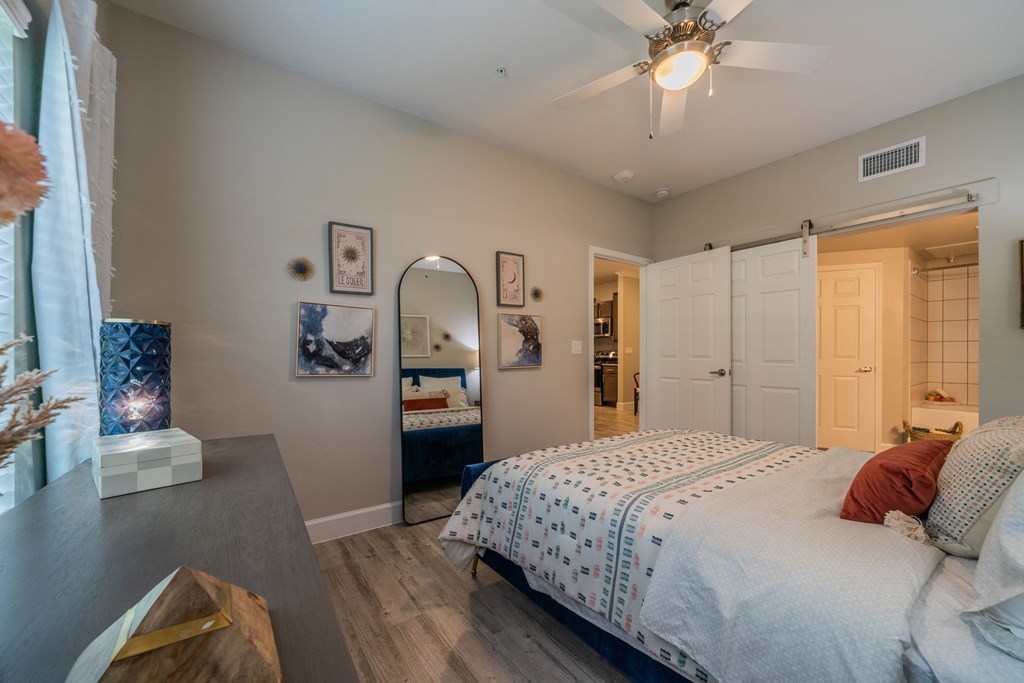 a bedroom with a large bed and a ceiling fan