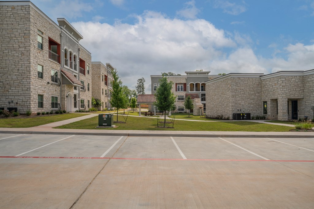 an empty parking lot in front of a brick building