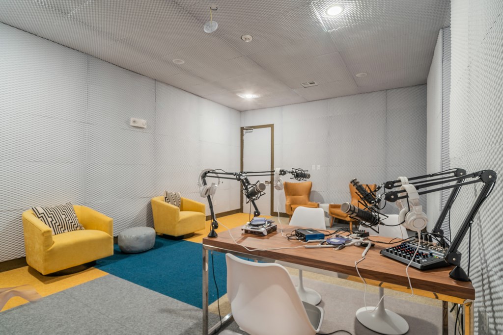 a recording studio with white walls and yellow chairs