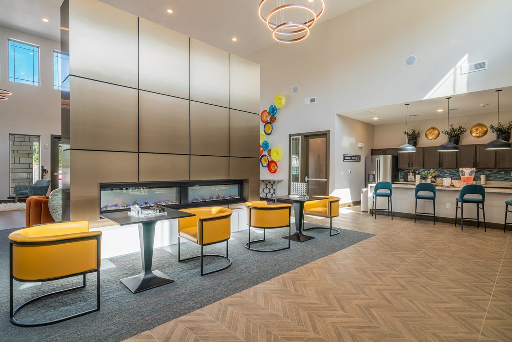 a communal area with tables and chairs and a fireplace