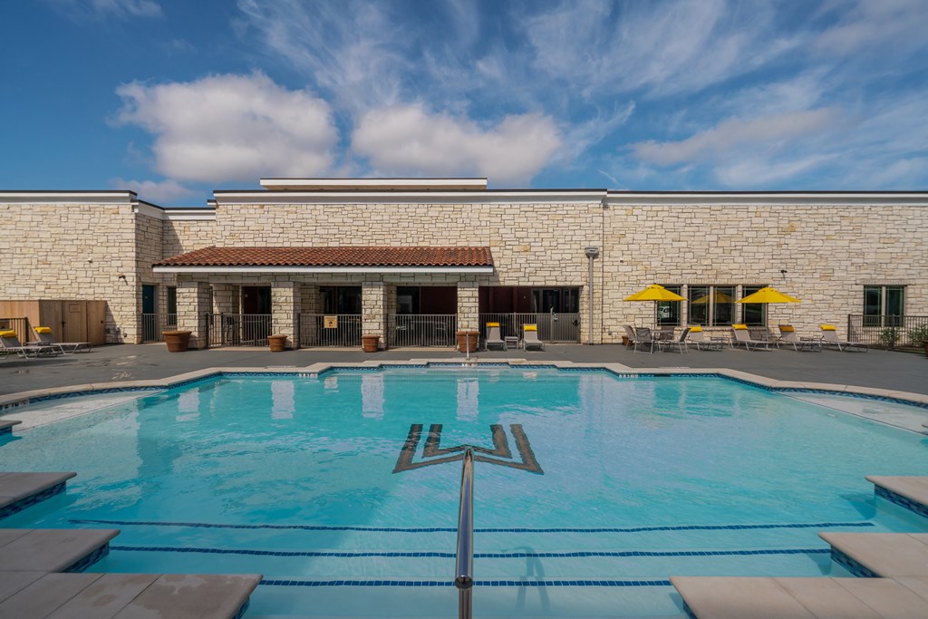 a large pool in front of a brick building