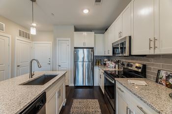 a kitchen with white cabinets and granite countertops
