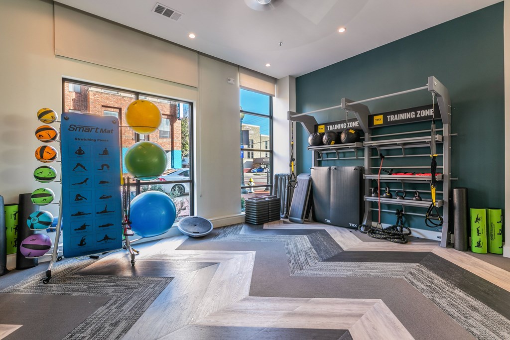 A gym with a variety of equipment including a blue exercise ball and a green exercise mat.