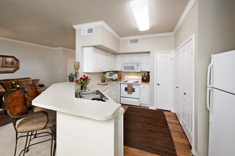 A kitchen with white cabinets and a white refrigerator.
