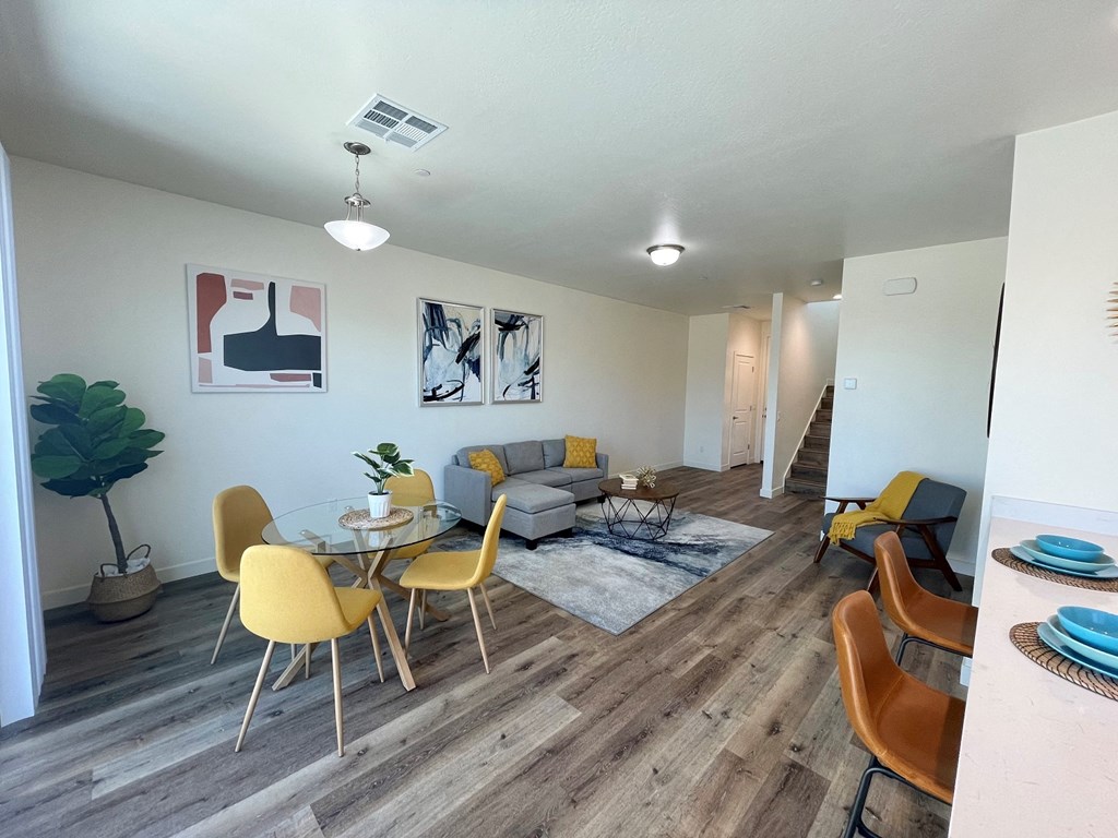 a living room and dining room with a table and chairs