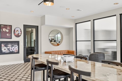 A modern dining room with a marble table and chairs.