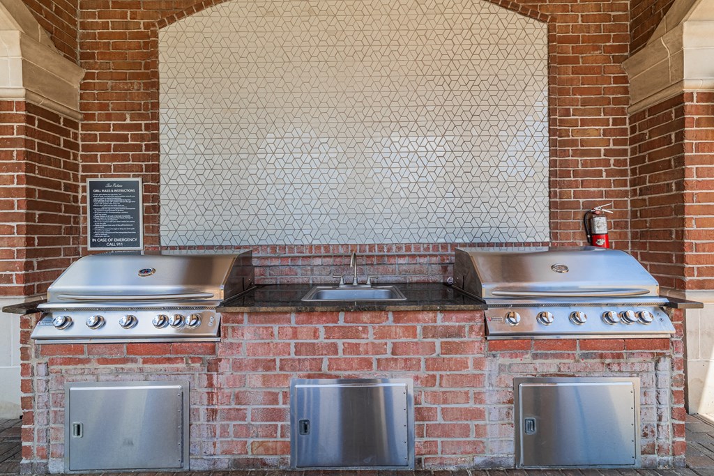 a kitchen with two stoves and three stainless steel stoves
