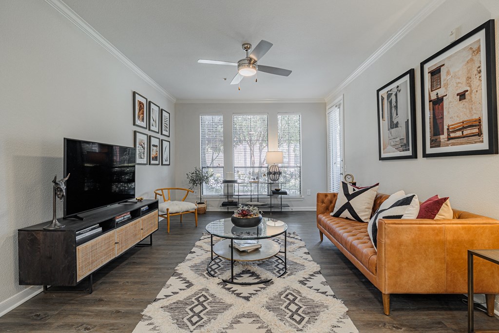 a living room with a ceiling fan and a large window