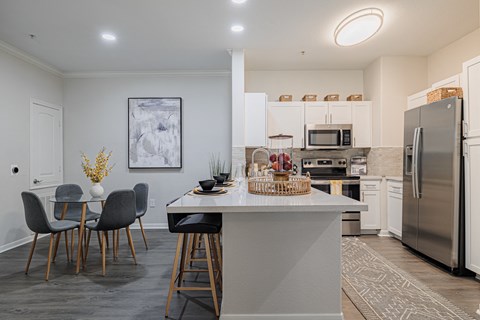 kitchen and dining area with stainless steel appliances and a table with chairs