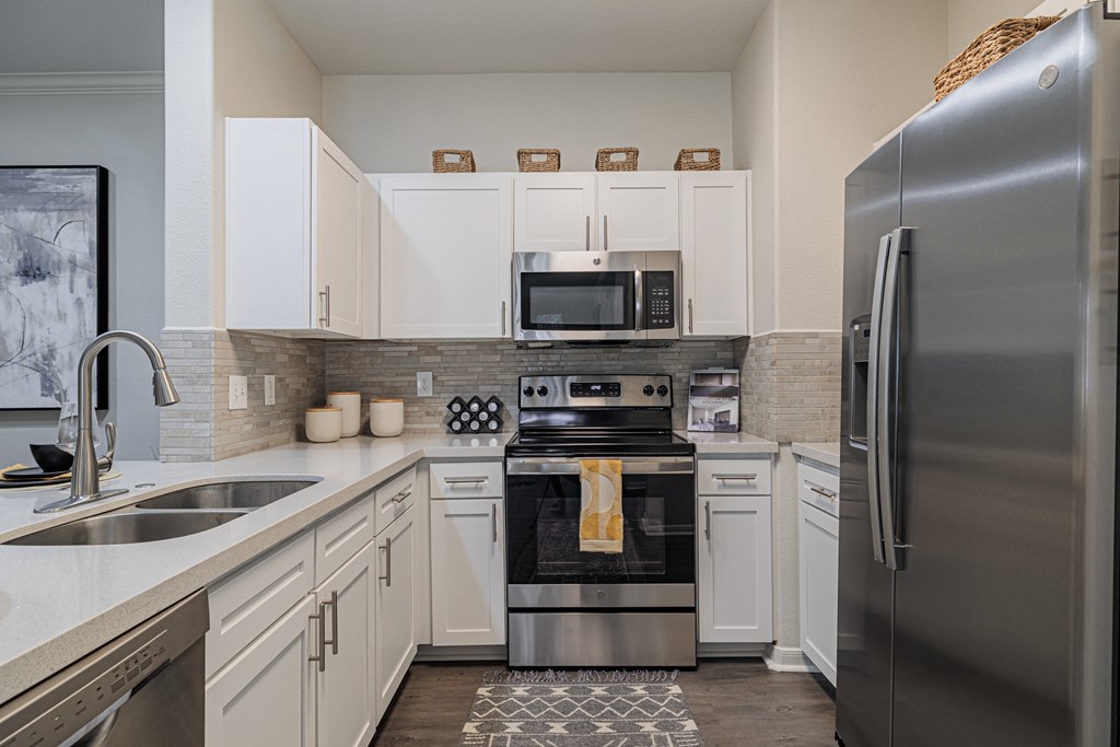 a kitchen with white cabinets and stainless steel appliances