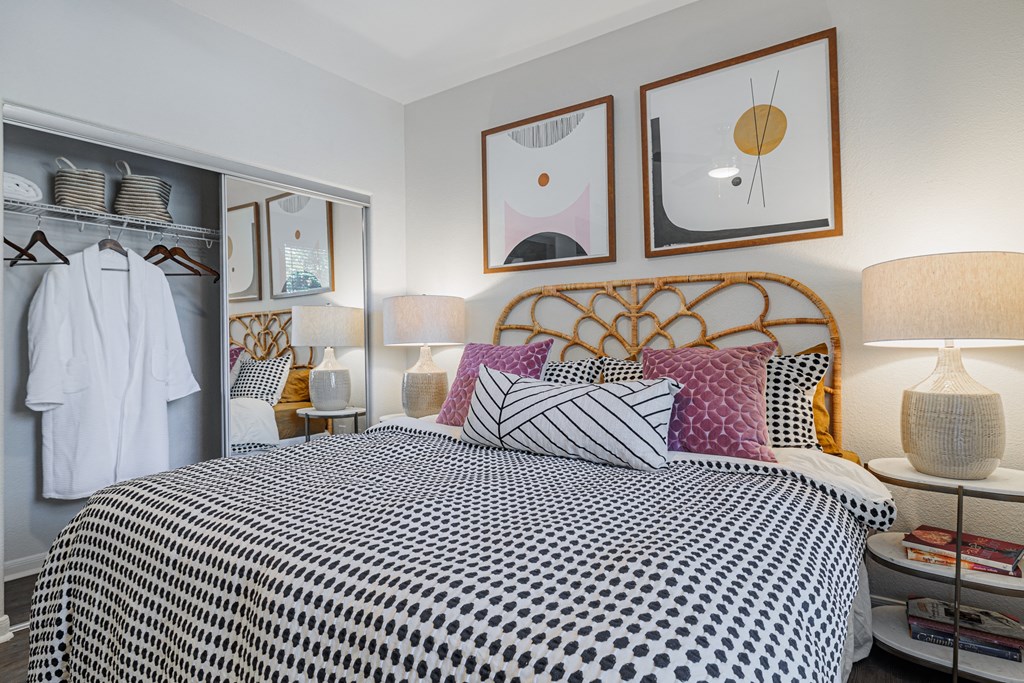a bedroom with a bed with a black and white comforter and colorful pillows