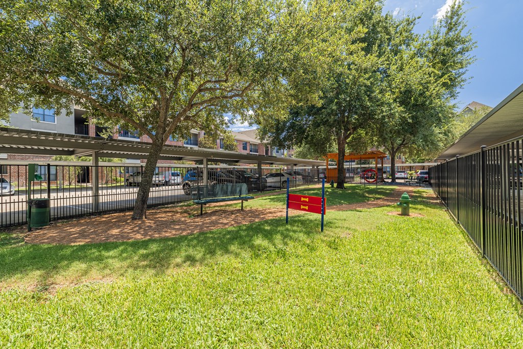 a park with trees and a bench in front of a building