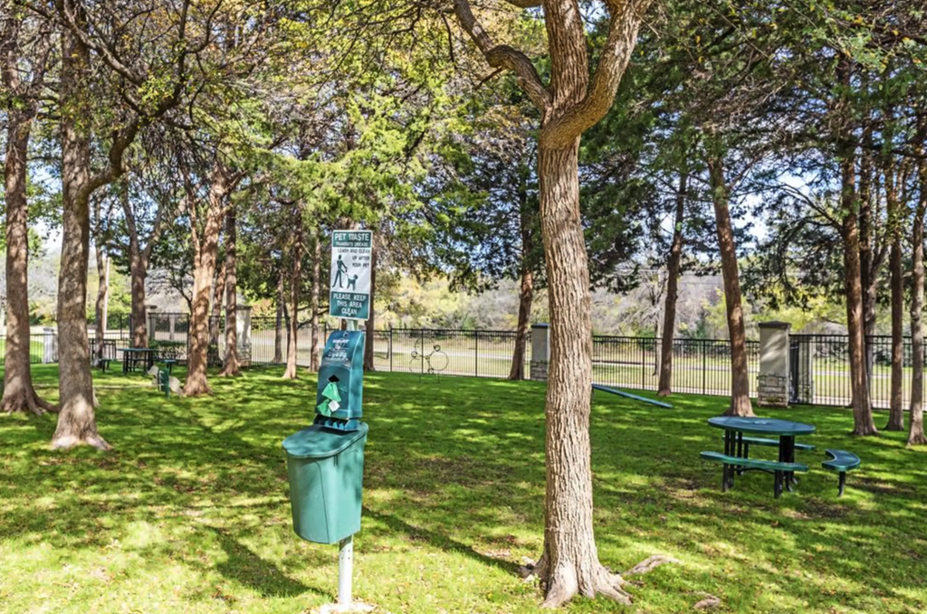 a park with a trash can and a picnic table