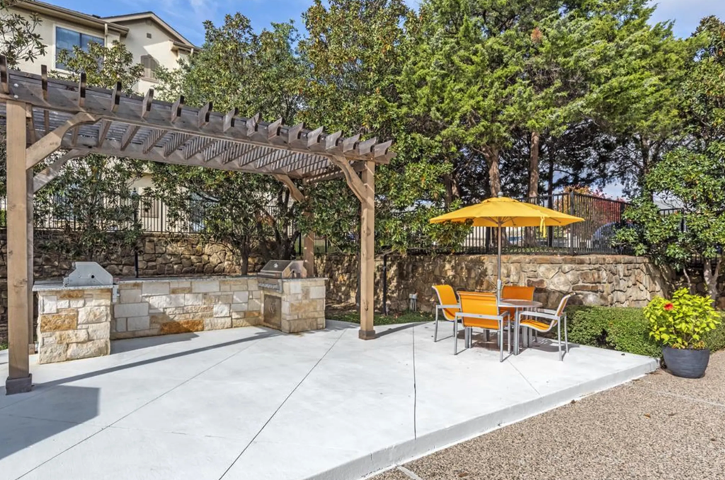 a patio with a table and chairs under a pergola