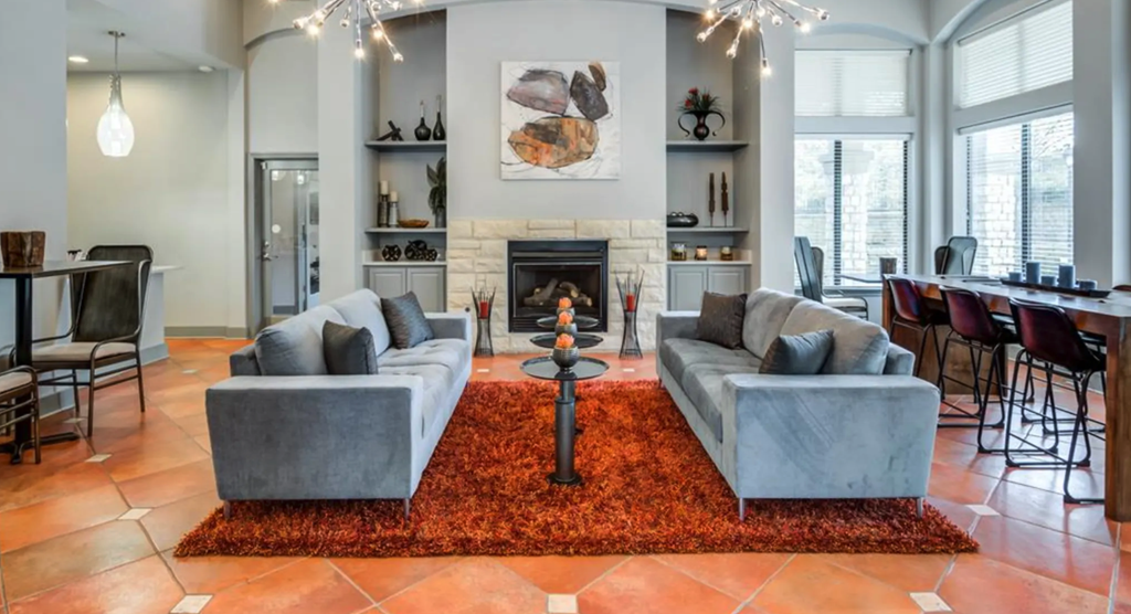 a living room with couches and a rug in front of a fireplace
