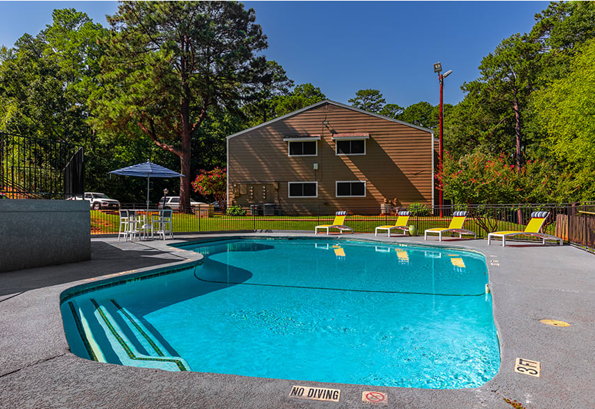 a swimming pool with a house in the background