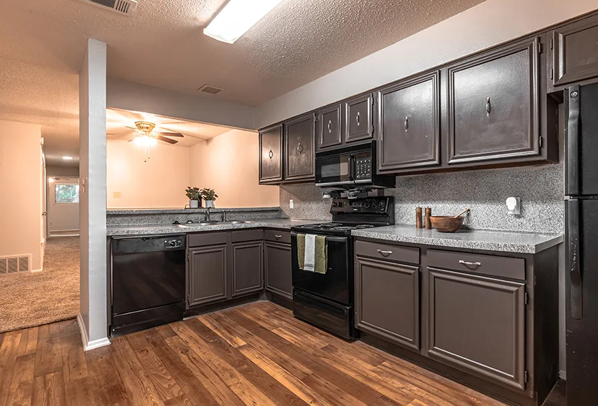 a kitchen with stainless steel appliances and dark cabinets