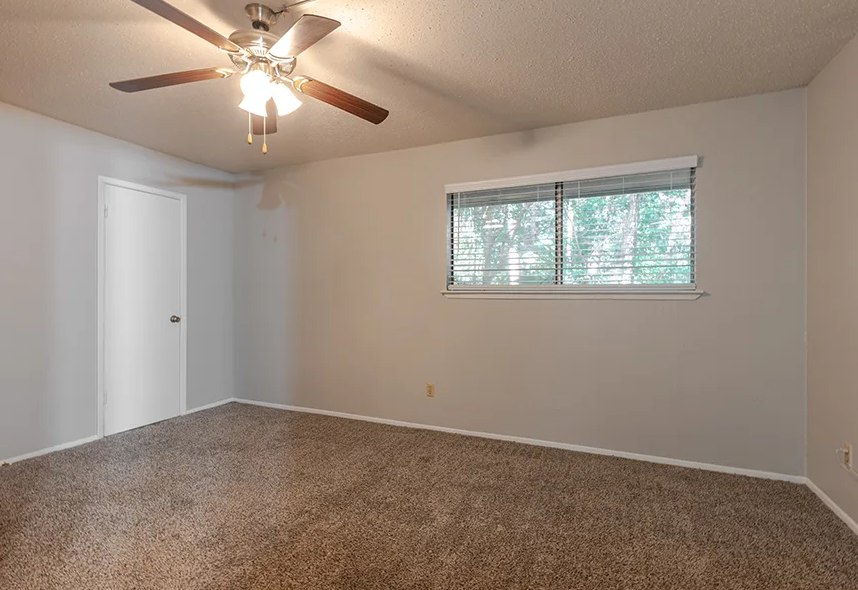 a bedroom with a ceiling fan and a window