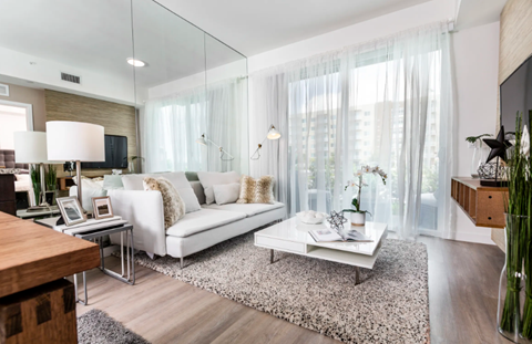 A modern living room with a white sofa and a glass table.